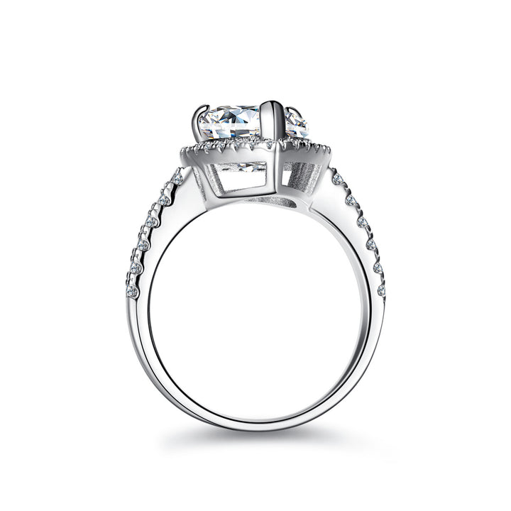 Silver ring with a large diamond and smaller diamonds on the band against a white background